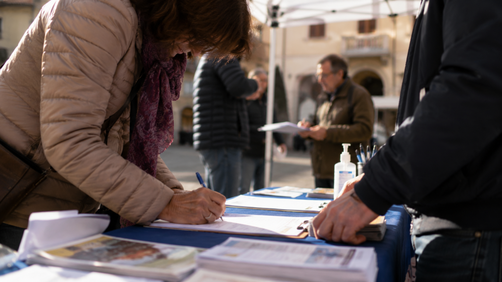 Fotografia editoriale realistica formato 16 di pomeriggio in una piazza di una cittadina toscana